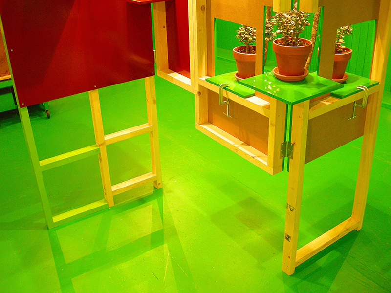 Jade plants set into the red and green room divider, image from SET THE CONTROLS FOR THE HEART OF THE SUN, installation at WRKS DVSN, by Kennedy Telford, 2006.
